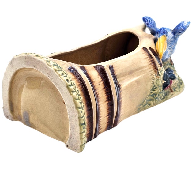This mid-century Japanese ceramic planter features a molded log form with a perched pelican rendered in hand-painted blue,...