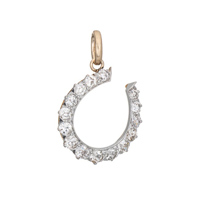 Finely detailed antique Victorian horseshoe pendant crafted in 14 karat yellow gold and platinum (circa 1880s to 1900s)....