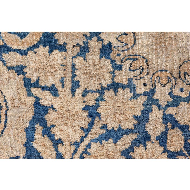 A late 19th century Persian Kirman rug, the royal blue field with a playful trellis design of palmettes and leafy vinery...