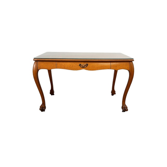 A timeless vintage tiger oak writing desk featuring elegant cabriole legs terminating in carved ball-and-claw feet....