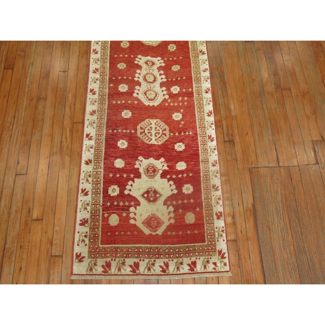 An early 20th century turkish oushak runner in a vibrant red