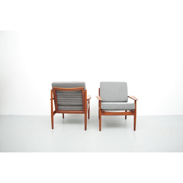 Lounge chairs made of solid teak with loose cushions. These chairs were acquired in 1958 and have been completely...