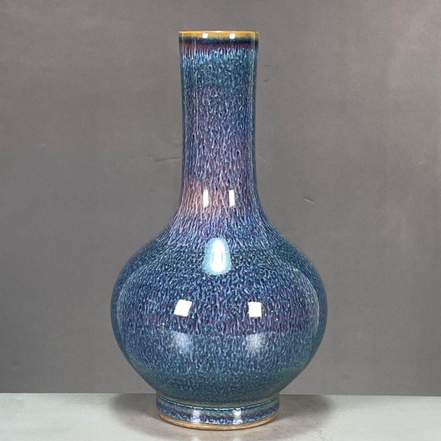 A beautiful Chinese porcelain bottle vase featuring a classic Jun ware style flambe glaze. The vase has a bulbous body and...