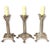 Set of three metal candlestick holders with footed bases. They are heavy and stable. Cast metal with a silver finish....