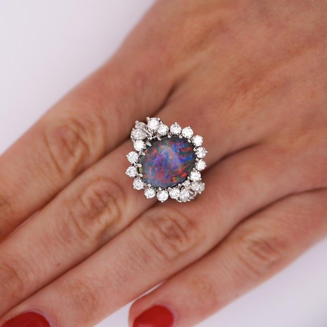 GIA Certified 5 Carat + Black Opal with vibrant play-of-color takes center stage in this vintage 14K white gold ring,...