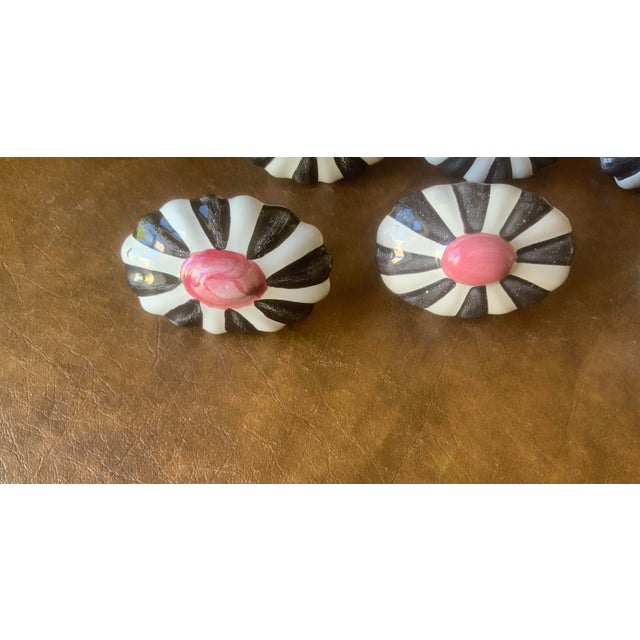 Signature black and white stripes frame a pink center; hand painted ceramic