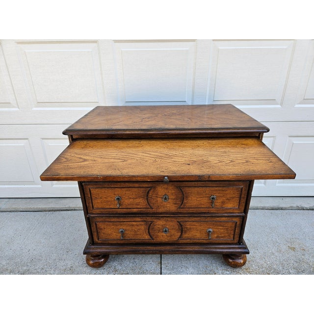 This three-drawer chest sits atop bun feet and is in the style of an early English William and Mary style chest of...