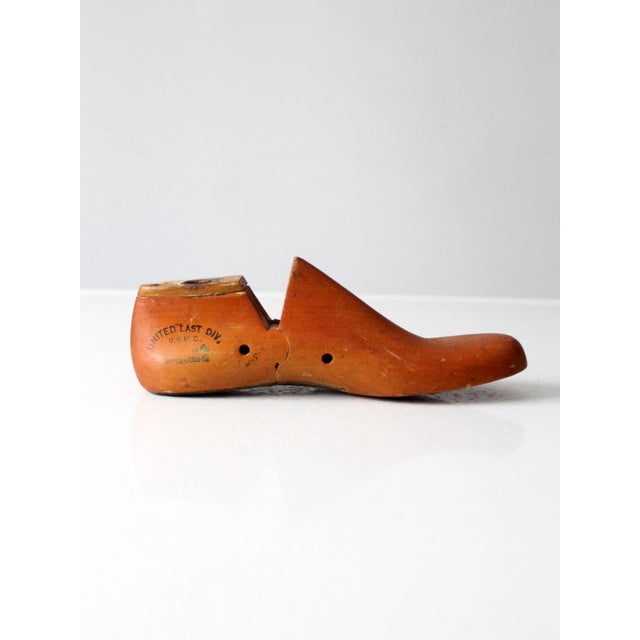 A vintage 1930s articulated wooden shoe last by United Shoe Machinery, retaining its warm worn finish, industrial...