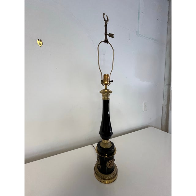 Beautiful neoclassical lamp in Black porcelain and brass ormolu laurel mounts. Classic design set atop a brass base.