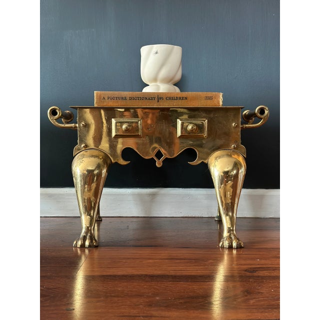 Handsome English brass footman designed for the fireside. The rectangular top sits above a shaped apron with diamond and...