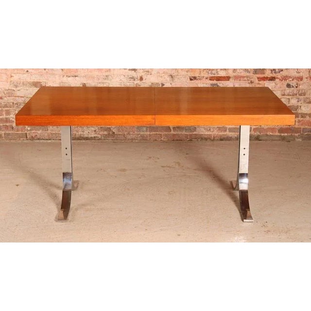 Danish Mid Century extending teak dining table with chrome legs by Poul Norrelikt for Dyrlund, circa 1970s. One extension...