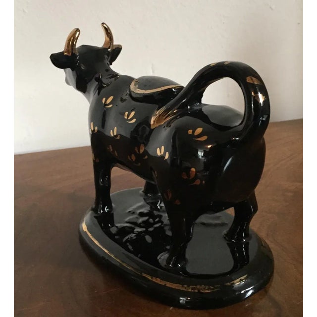 Antique 19th c. English pearlware Jackfield cow form cream jug decorated with black glaze enhanced by gilding. A small...