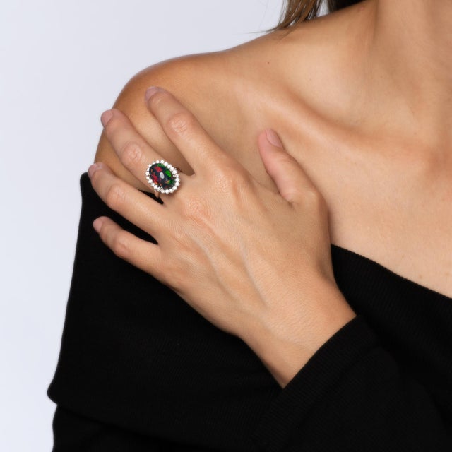 Stylish contemporary Ethiopian black opal & diamond ring crafted in 14 karat white gold. Natural freeform oval cabochon...