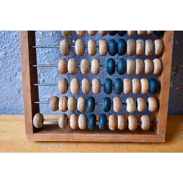 This large abacus of Soviet origin is made entirely of wood. Antique, it has been patinated by years of counting rubles...
