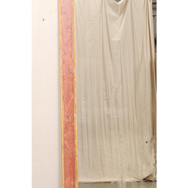 An Italian large-sized painted wood mirror from the turn of the 19th and 20th century. This antique mirror from Italy is a...