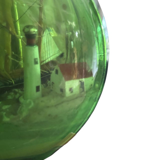 A charming vintage nautical table lamp featuring a handcrafted ship-in-a-bottle maritime diorama encased within a striking...