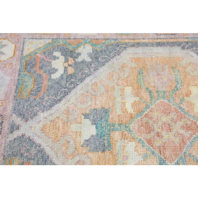 This modern Turkish Oushak rug is a stunning piece of art that has been handwoven using traditional techniques by skilled...