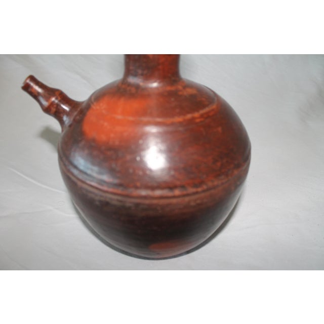 A kendi is a traditional, handle-less pouring vessel from Southeast Asia, originating from the Indian kundika,...