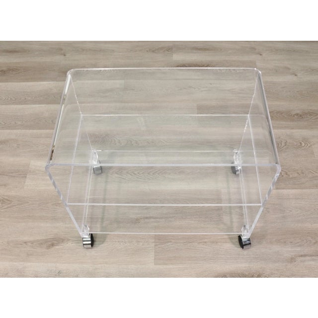 Vintage bar cart or occasional table on wheels, formed of Lucite (clear acrylic) on four easy pull chromed wheels....