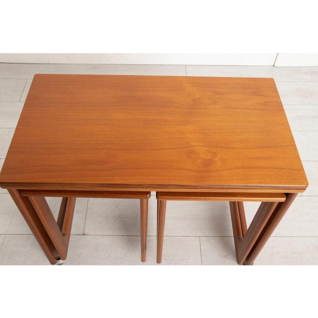 A mid-century mcintosh triform nest of three tables with a fold-out tabletop circa 1960s. In excellent condition. H: 60cm...