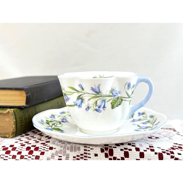 This Dainty Shape Shelley tea cup is decorated in the blue Harebell pattern (No. 13590). Made of fine English bone china,...