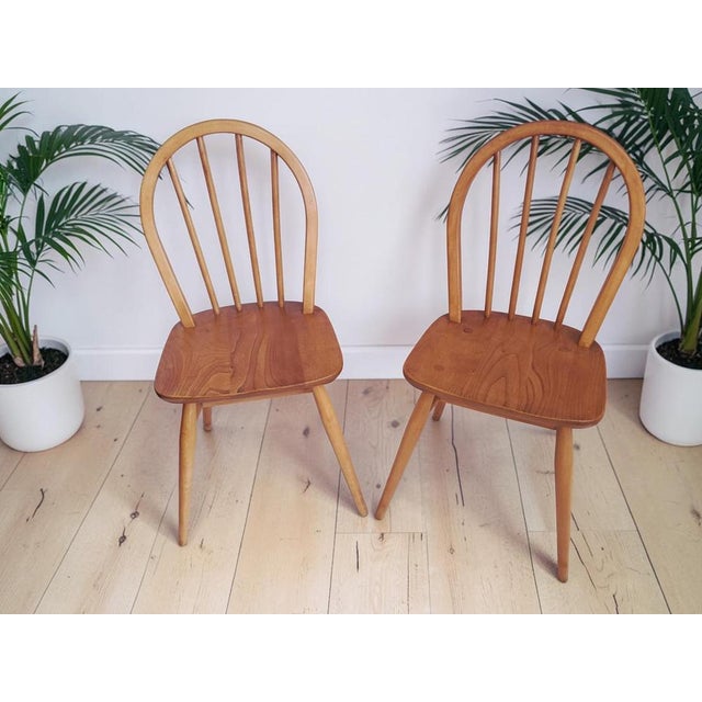 Introducing our exquisite vintage pair of Ercol Windsor dining chairs. Designed by the renowned Luciano Ercolani for Ercol...