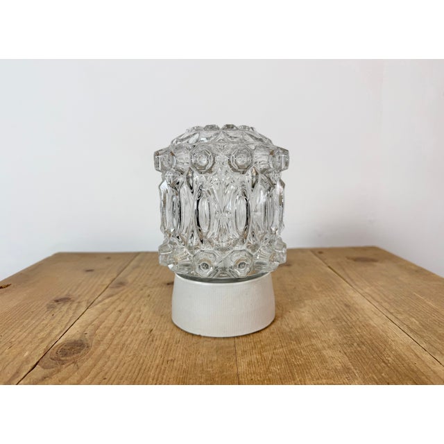 Vintage industrial ceiling or wall light made in former Czechoslivakia during the 1970s. It features a white porcelain...