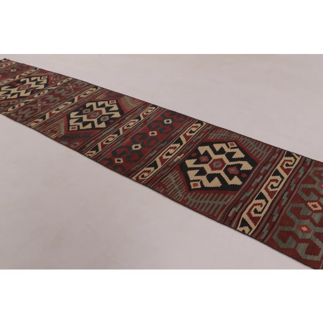 This vintage Afghan kilim runner, measuring 3x15 and dating to circa 1950-1960, is a striking example of mid-century...