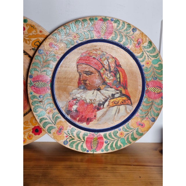 Pair of vintage Czech Republic Hroznová Lhota-style folk art portrait wooden decorative plates. Unsure of period item was...