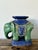 This vintage glazed ceramic elephant low stool is a vibrant celebration of sculptural form and decorative artistry,...