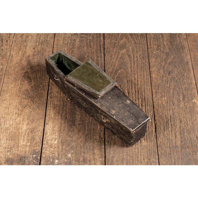Small coffin-form wooden presentation box with a hinged flip-top lid, finished in worn black paint over a simple plank-...