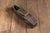 Small coffin-form wooden presentation box with a hinged flip-top lid, finished in worn black paint over a simple plank-...