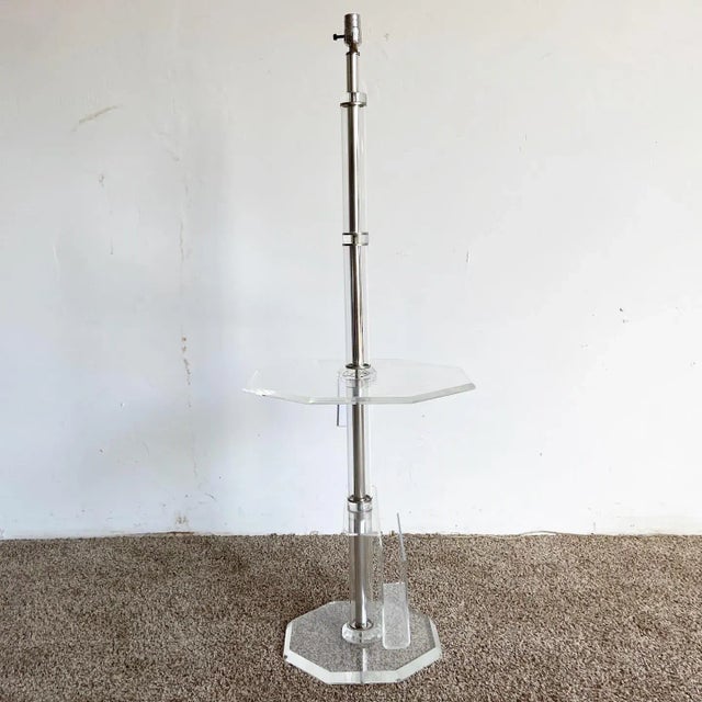 Exceptional vintage postmodern lucite floor lamp/side table with a magazine rack at the bottom. The stem displays a good...