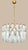 DUTIES FREE A sculptural chandelier featuring a circular metal structure with a refined gold finish, suspended from a...