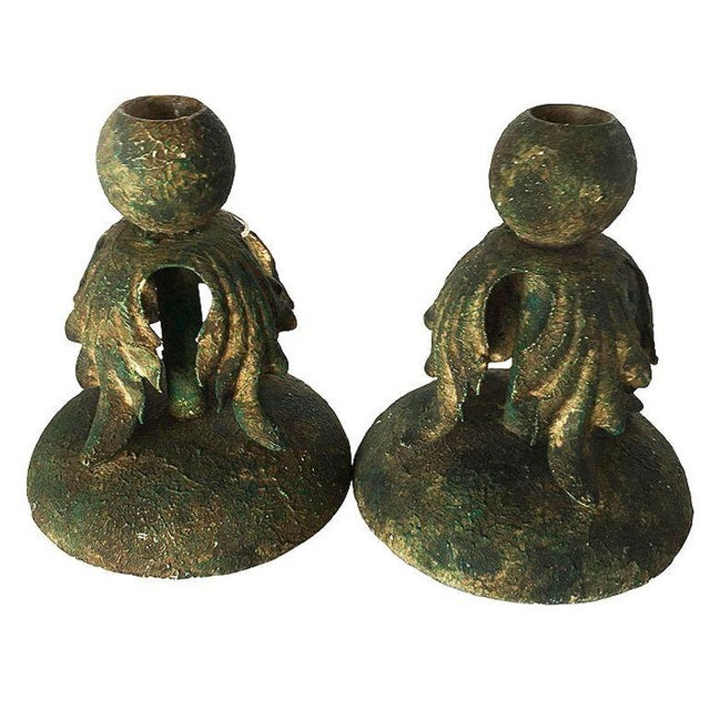 Pair of cast iron candlestick holder with baroque leaf accents in a heavy patina.