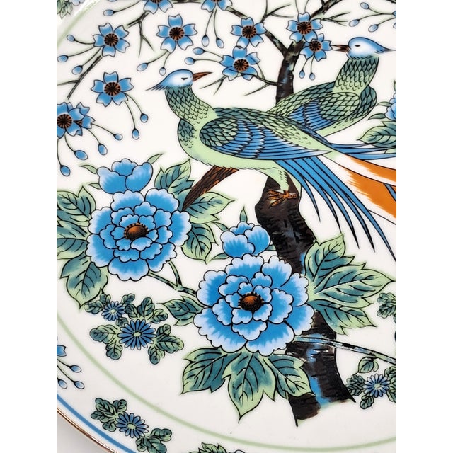 Vintage Imari ware plate featuring a long-tailed bird (resembling a paradise flycatcher) perched among blooming blue...