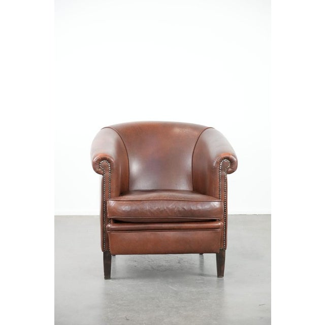 This unique cognac-colored English-style cowhide club armchair fits easily into almost any interior and has a classic yet...