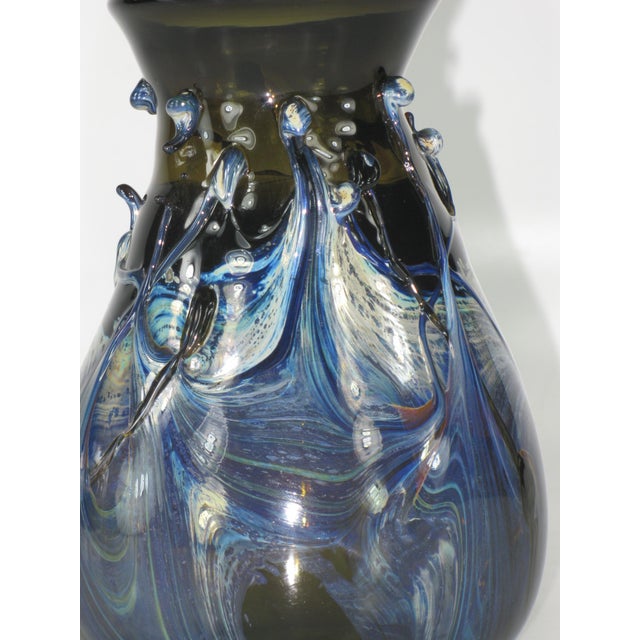 This exquisite blue glass vase is a masterpiece of handcrafted art. The vase is mouth blown and features a stunning blue...