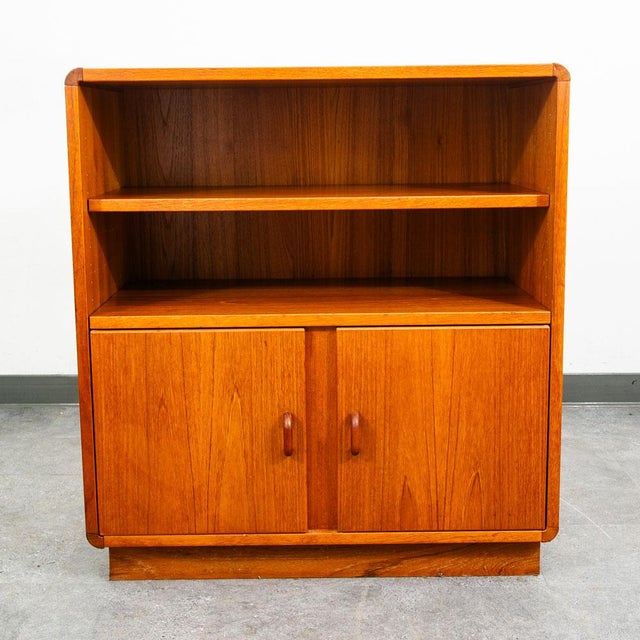 Danish teak bookshelf cabinet with 2 doors below and single shelf in the center. Unsigned example. Great for use as a...