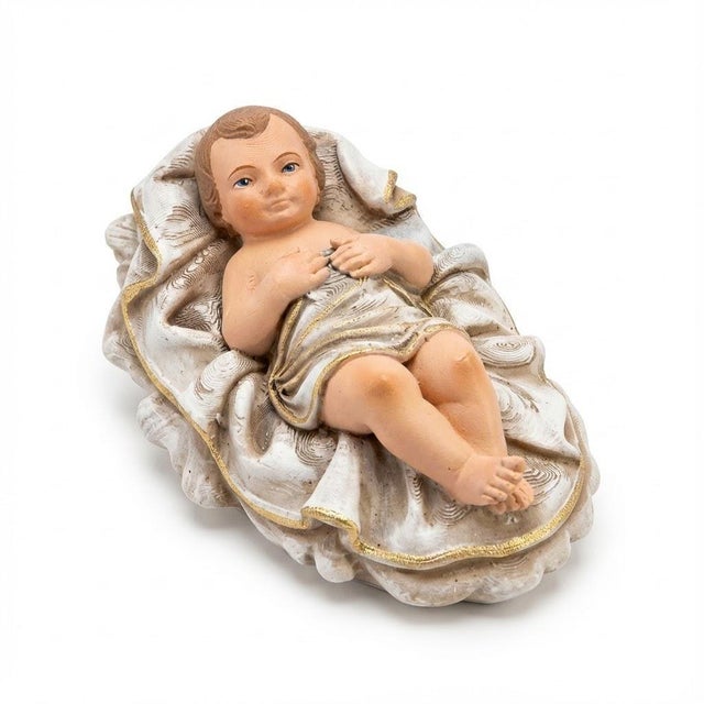 The Infant Jesus reclines on a softly sculpted cradle, with natural painted skin tones and ivory fabric accented in gold....