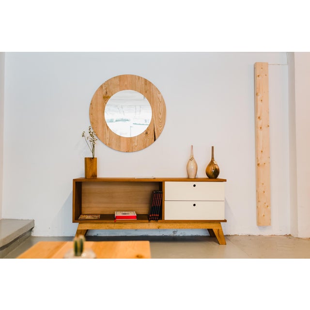 Palafinga is a wood credenza with an open storage compartment and two light-toned drawers. Its raised wood base and clean,...