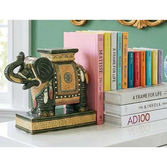 Vintage Hollywood Regency elephant bookends featuring richly detailed caparisoned elephants in deep green, gold, and ivory...