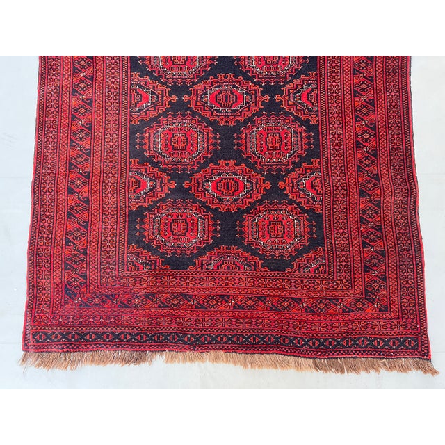 A vintage Afghan Ersari rug carrying two columns of large octagonal "elephant's foot" (Fil-pai) güls — each stepped...