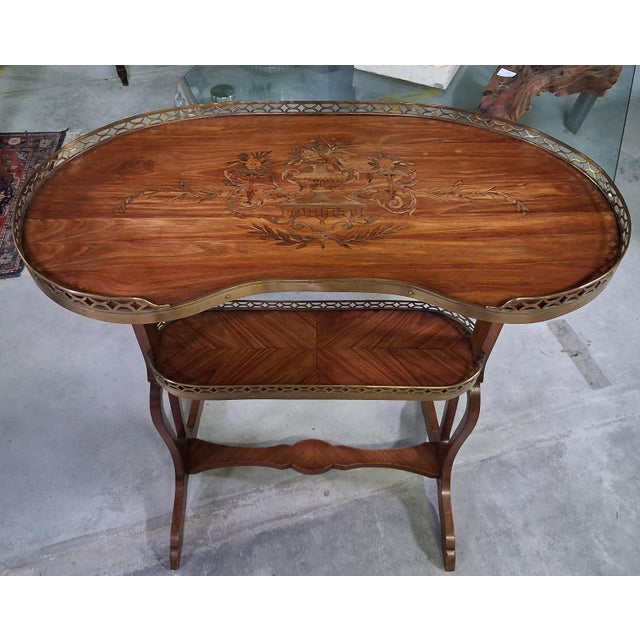 A two-tiered art nouveau tea table, featuring a light and refined silhouette characteristic of belle époque designs. the...
