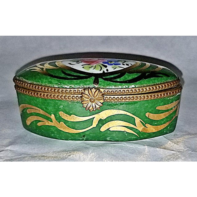 Classic French Limoges trinket box in porcelain with hand painted floral motif, gold plated brass trim.