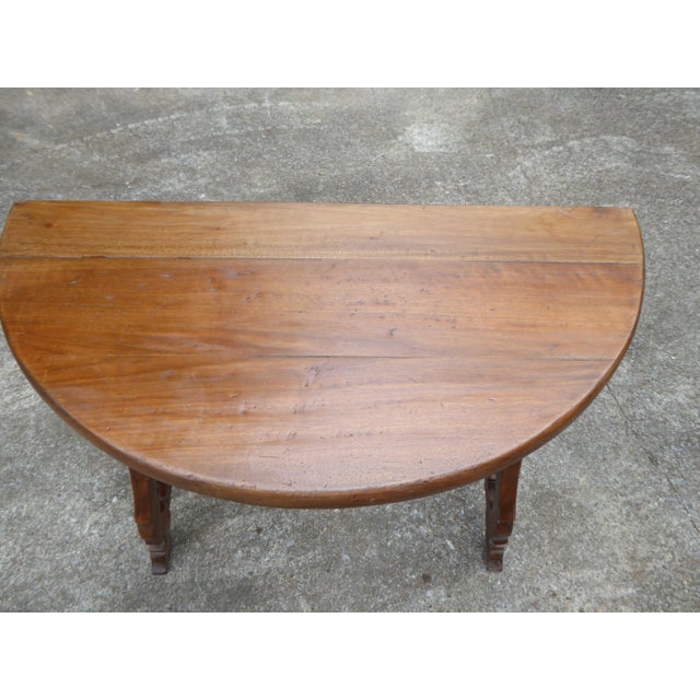 Wonderful walnut demilune w/h great patina and aged character. Robust and stable. Pegged with mild tooling. I'm told it...