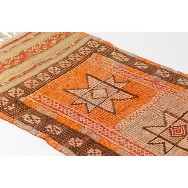 This is a vintage Turkish Oushak rug from the Mid 20th Century. The piece was hand-knotted.