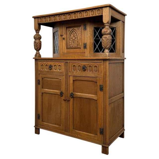 A beautifully crafted early 20th-century English court cupboard, constructed in golden oak and distinguished by its...