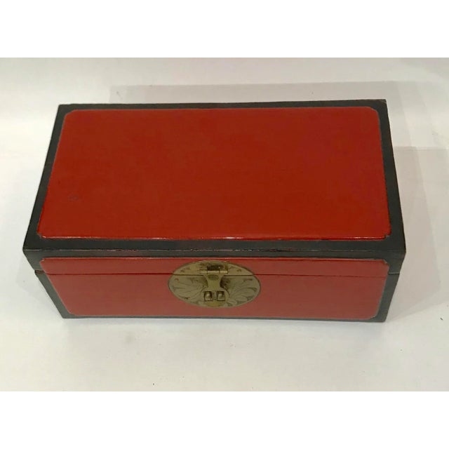 Eye-catching red and black lacquer-over-wood chest with stunning brass hardware. Overall red lacquer, edges lacquered in...