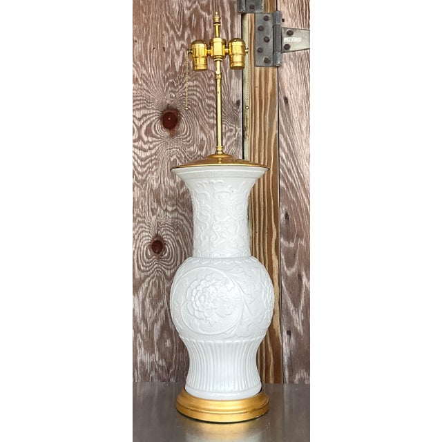 A stunning vintage Regency table lamp. Monumental in size and frame. Beautiful Blanc de Chine design with a gilt plinth....